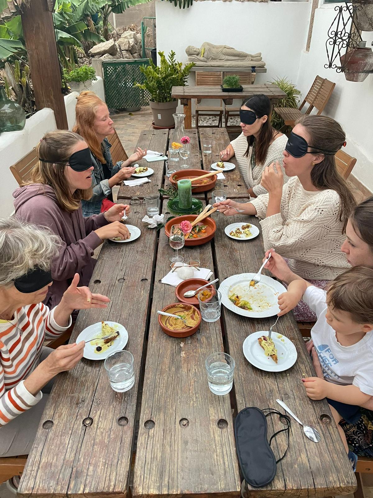 Blindfolded mindful eating around a long wooden table in Tenerife